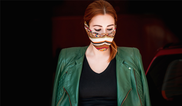 Red headed women in green jacket wearing a fashionable facemask